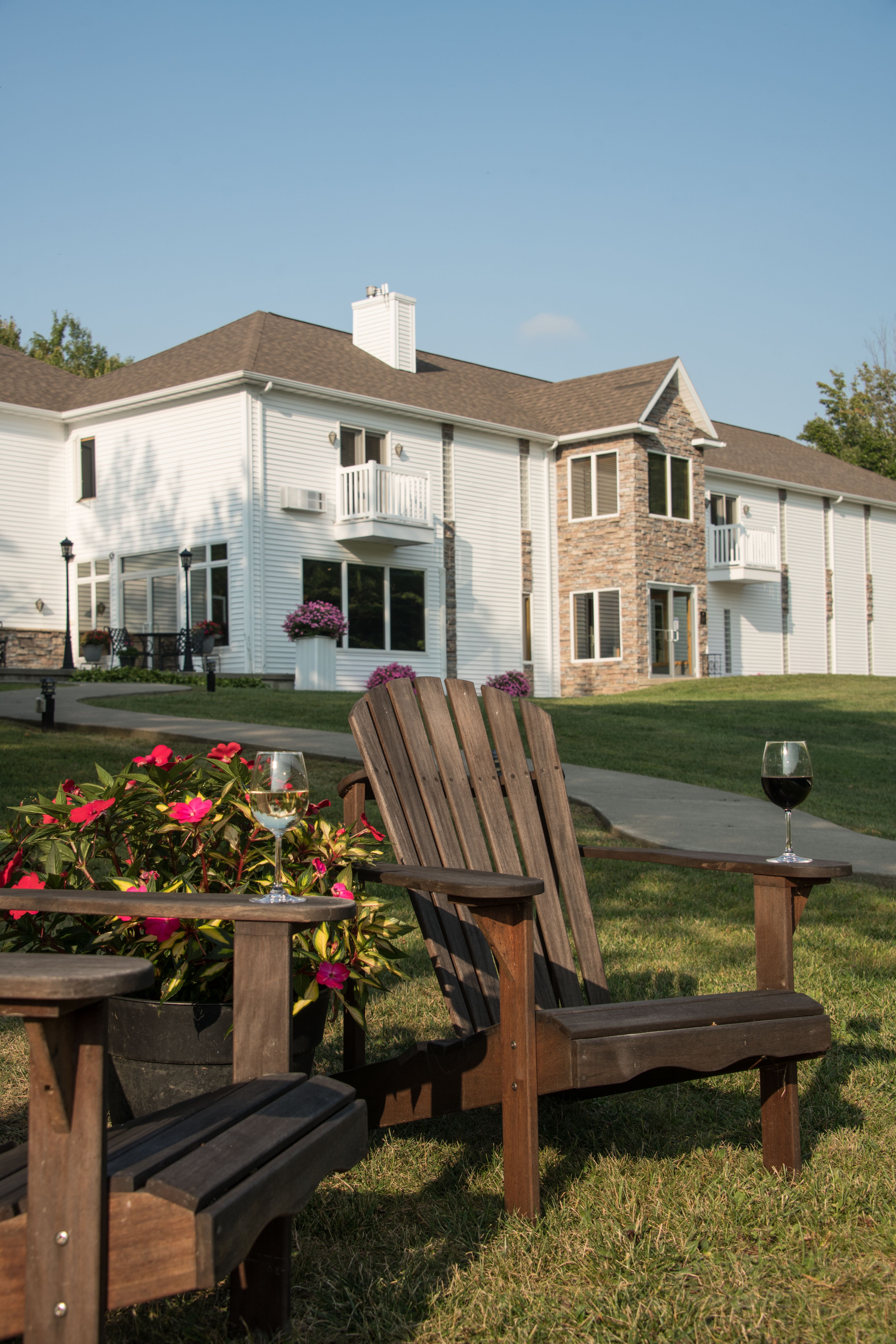 FLOWERS, ADIRONDACK CHAIRS, AND WINE IN FRONT OF RIVER SPRING LODGE